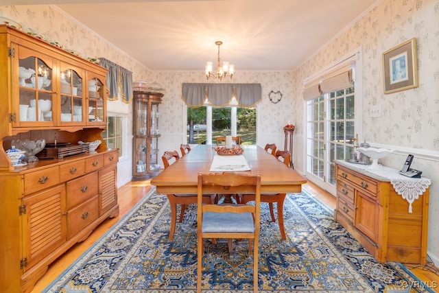 dining room with a wealth of natural light, light hardwood / wood-style flooring, and a chandelier