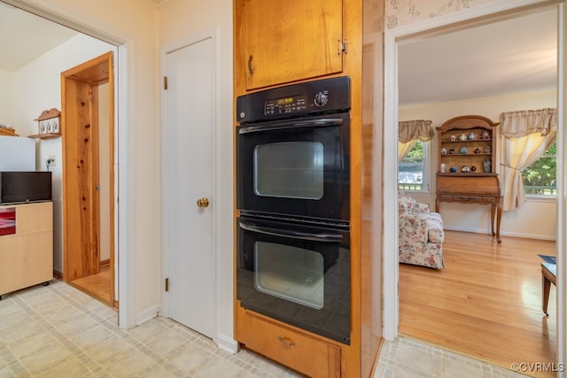 kitchen featuring light wood-type flooring, plenty of natural light, and double oven