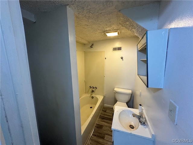 bathroom featuring vanity, hardwood / wood-style floors, a textured ceiling, and toilet