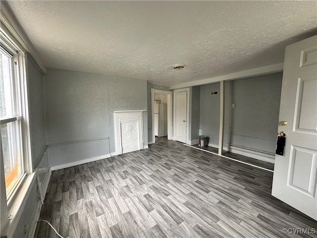 unfurnished room with hardwood / wood-style flooring and a textured ceiling