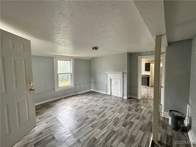 unfurnished living room with hardwood / wood-style floors and a textured ceiling