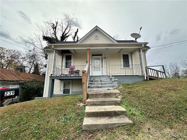 view of front of house featuring covered porch and a front yard