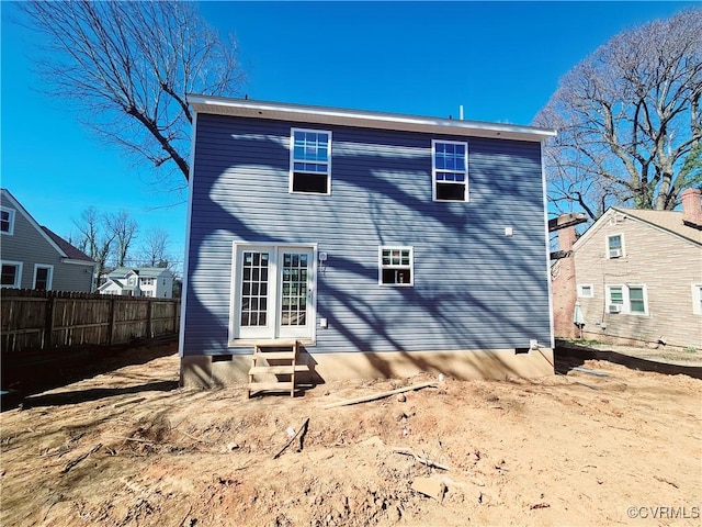 rear view of house with entry steps and fence