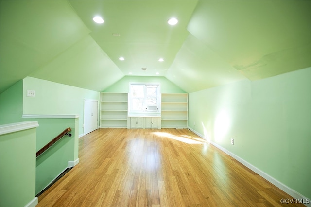 bonus room with light wood-type flooring and lofted ceiling