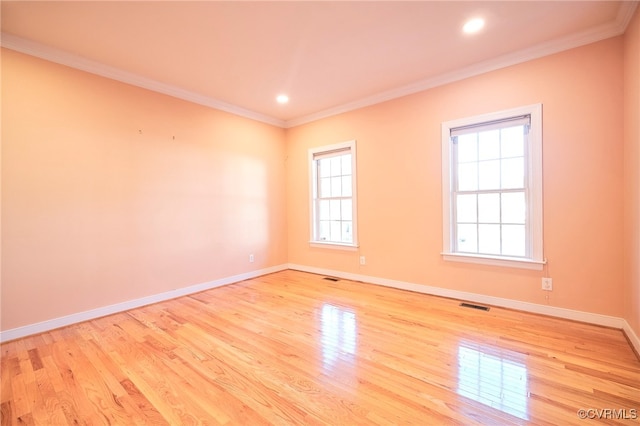 spare room featuring light hardwood / wood-style flooring and ornamental molding