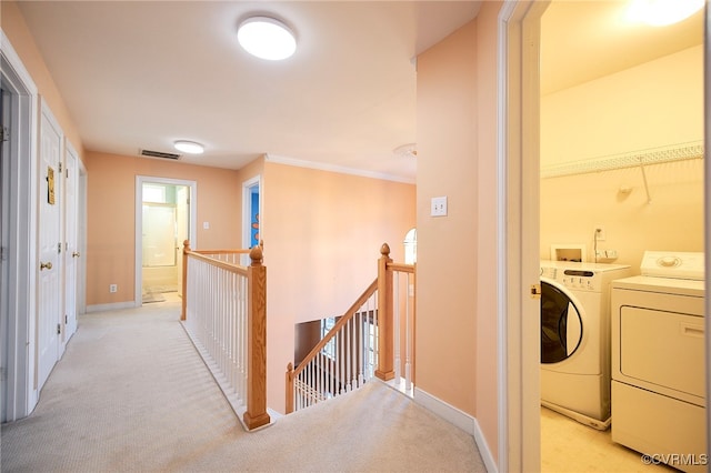 hallway with light colored carpet and independent washer and dryer