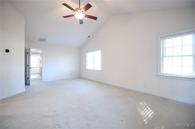 carpeted spare room featuring a wealth of natural light, ceiling fan, and high vaulted ceiling