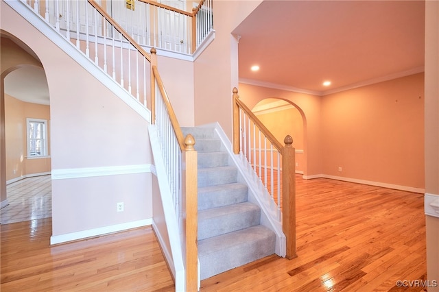 staircase featuring hardwood / wood-style floors and ornamental molding