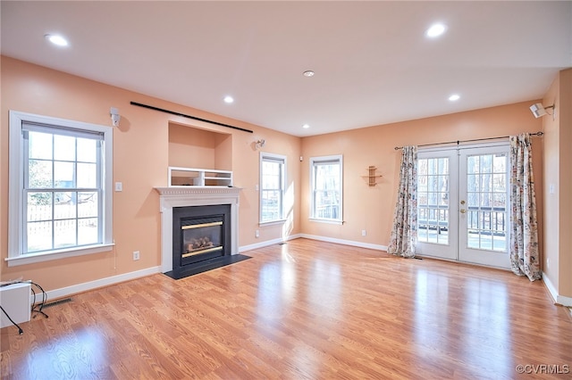 unfurnished living room with french doors and light hardwood / wood-style flooring