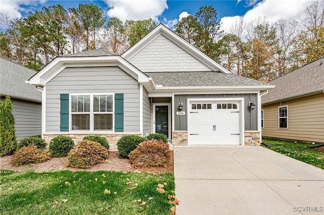 view of front of home with a garage, stone siding, board and batten siding, and concrete driveway