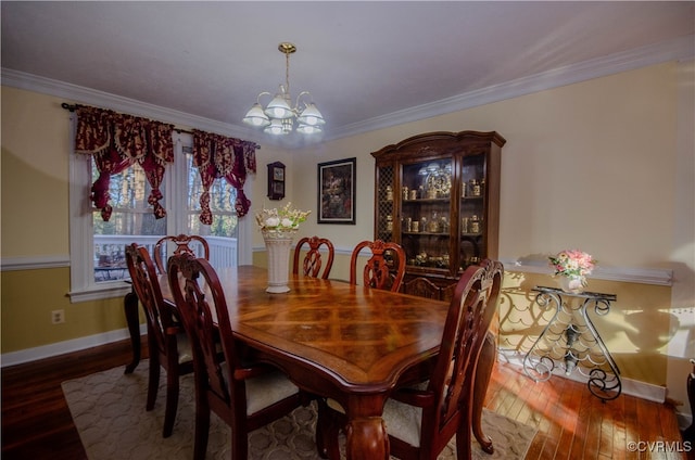 dining space featuring crown molding, a chandelier, and hardwood / wood-style flooring