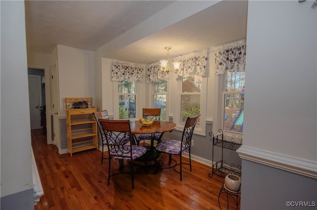 dining room with dark hardwood / wood-style flooring and a chandelier