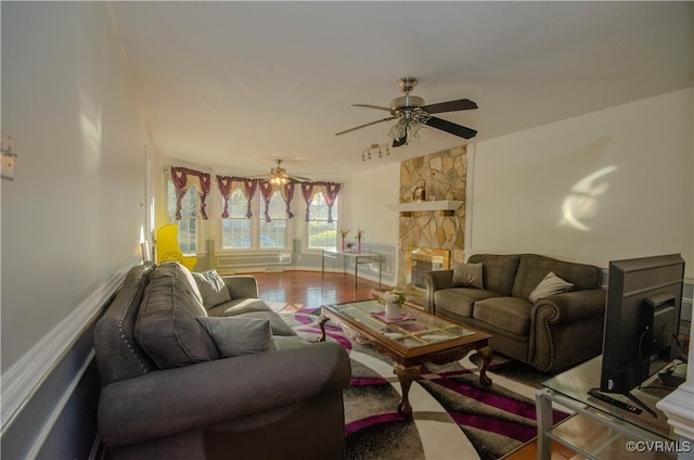 living room with ceiling fan, a fireplace, and hardwood / wood-style flooring