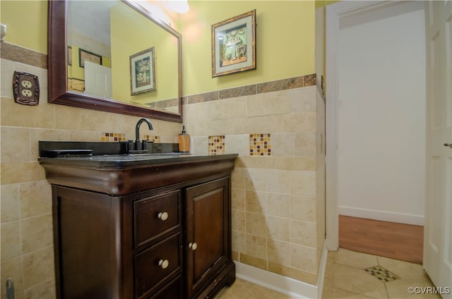 bathroom featuring tile patterned flooring, vanity, and tile walls