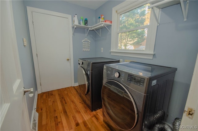 washroom with washer and clothes dryer and light hardwood / wood-style flooring