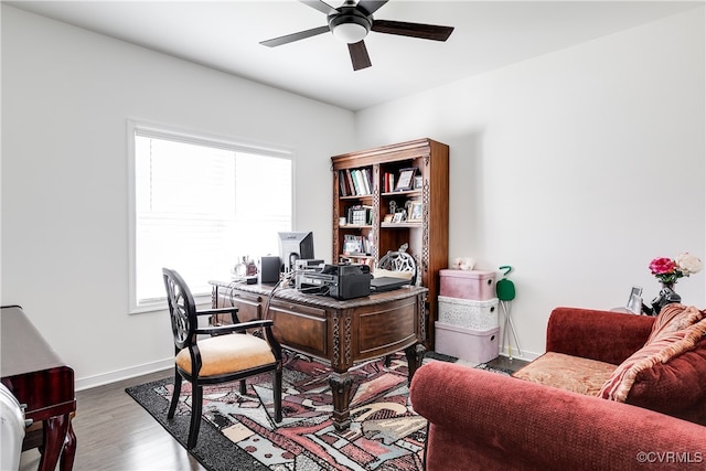 office with light wood-type flooring and ceiling fan