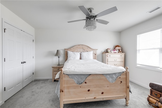 carpeted bedroom with ceiling fan and a closet