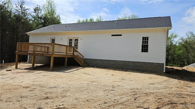 rear view of property featuring a wooden deck and stairs