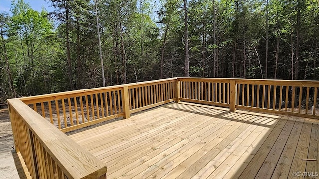 wooden deck with a wooded view