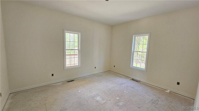 unfurnished room featuring baseboards, visible vents, and a healthy amount of sunlight