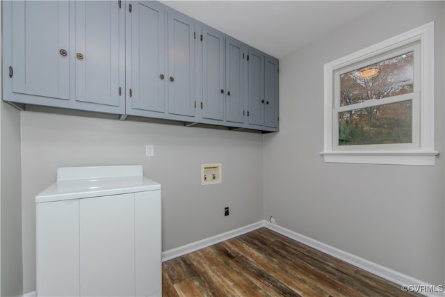 washroom featuring dark hardwood / wood-style flooring, cabinets, and washer / dryer