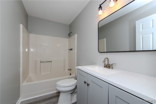 full bathroom featuring toilet, hardwood / wood-style floors, vanity, and washtub / shower combination