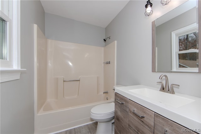 full bathroom with shower / tub combination, toilet, vanity, and hardwood / wood-style flooring