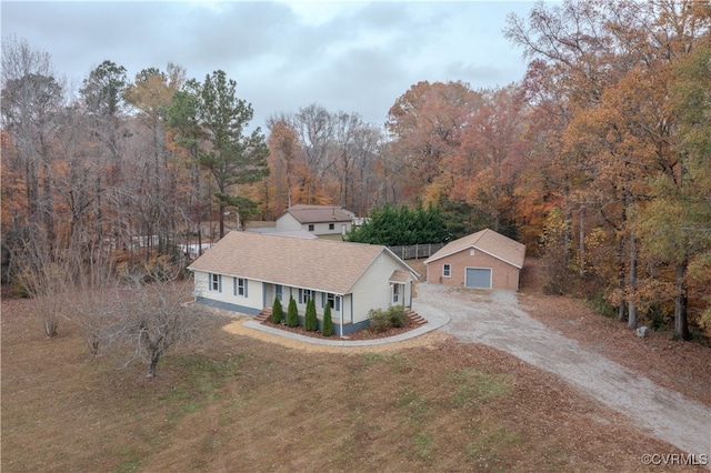 view of front of home featuring a garage, a front lawn, and an outdoor structure