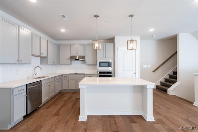 kitchen featuring gray cabinetry, light wood-type flooring, sink, and appliances with stainless steel finishes