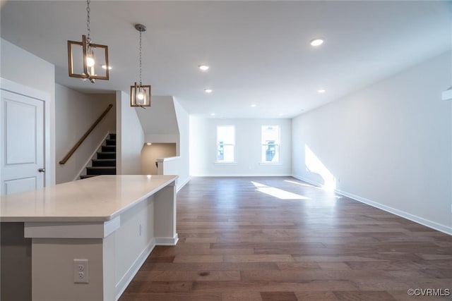 interior space with a notable chandelier, decorative light fixtures, a center island, and dark hardwood / wood-style flooring