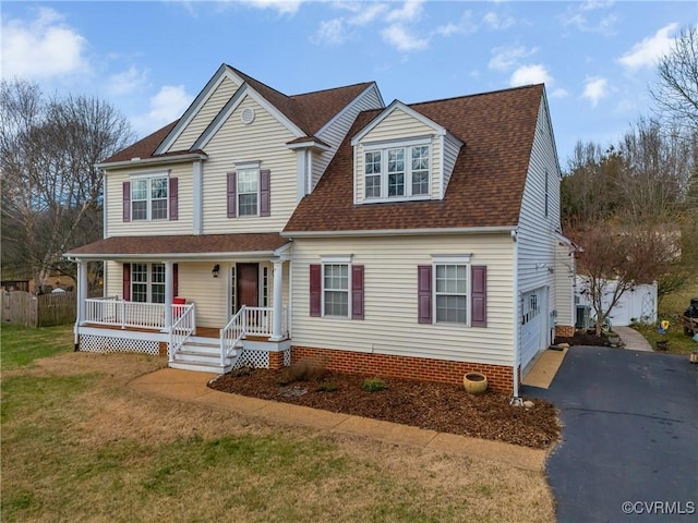 view of front facade featuring a porch, a garage, and a front lawn