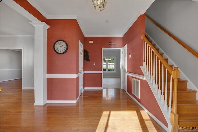 corridor with a chandelier, light hardwood / wood-style floors, and ornamental molding