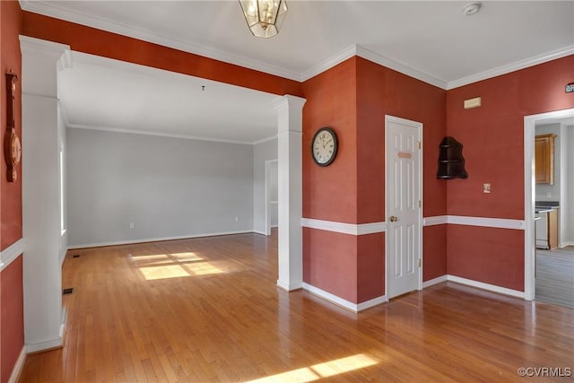 empty room with hardwood / wood-style floors and ornamental molding