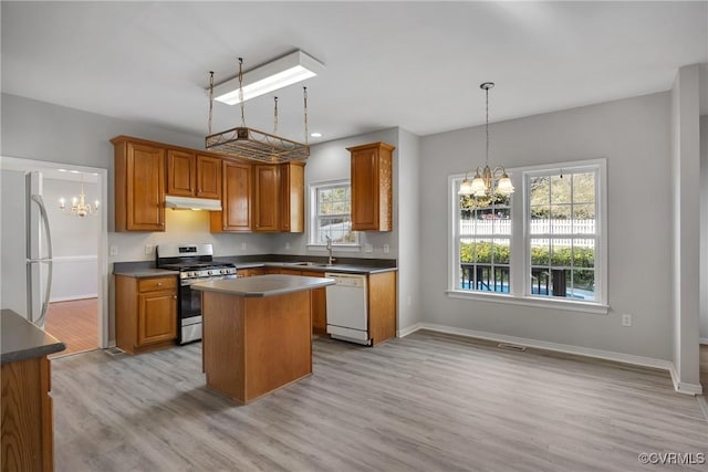 kitchen with a healthy amount of sunlight, a kitchen island, stainless steel appliances, and light hardwood / wood-style floors