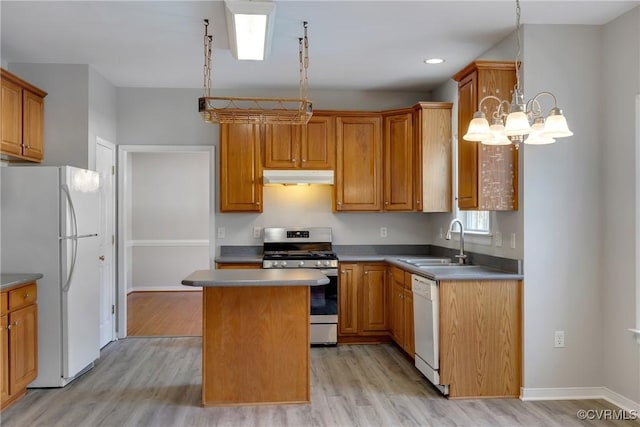 kitchen featuring white appliances, sink, a kitchen island, light hardwood / wood-style floors, and a chandelier