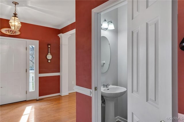 foyer featuring sink, ornamental molding, and light wood-type flooring