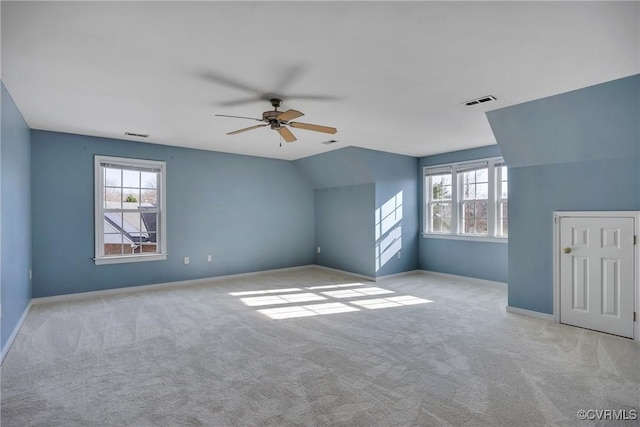 bonus room with plenty of natural light, ceiling fan, light colored carpet, and vaulted ceiling