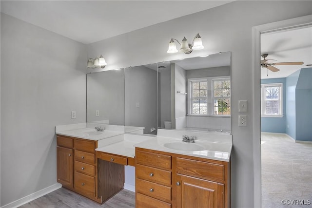 bathroom with ceiling fan, vanity, and wood-type flooring