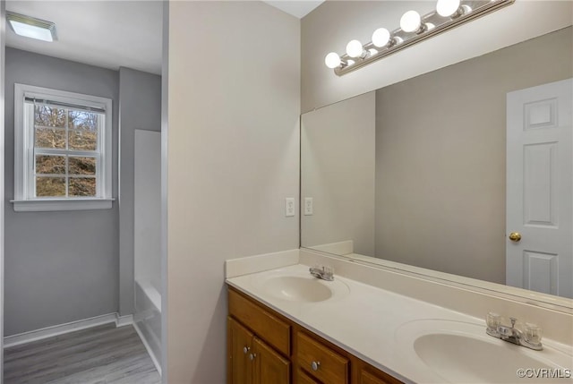 bathroom with a bath, hardwood / wood-style floors, and vanity