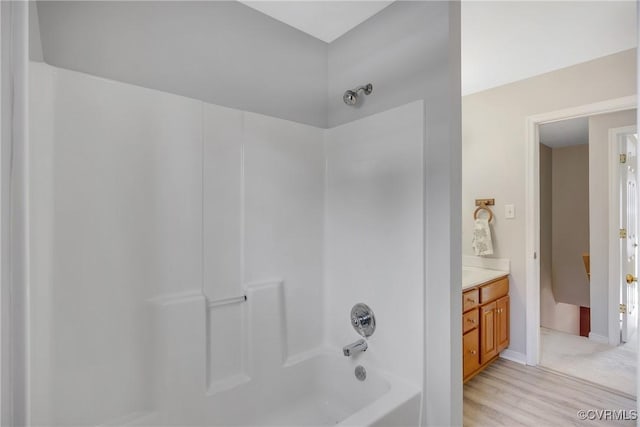 bathroom with shower / bathing tub combination, vanity, and wood-type flooring