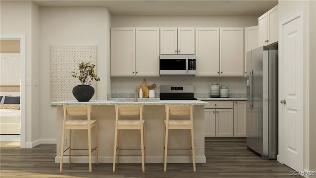 kitchen featuring appliances with stainless steel finishes, dark wood-style flooring, white cabinetry, and a kitchen bar