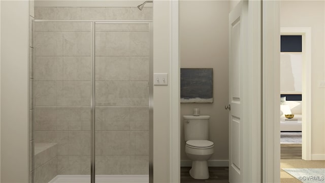 full bathroom featuring a stall shower, baseboards, and toilet