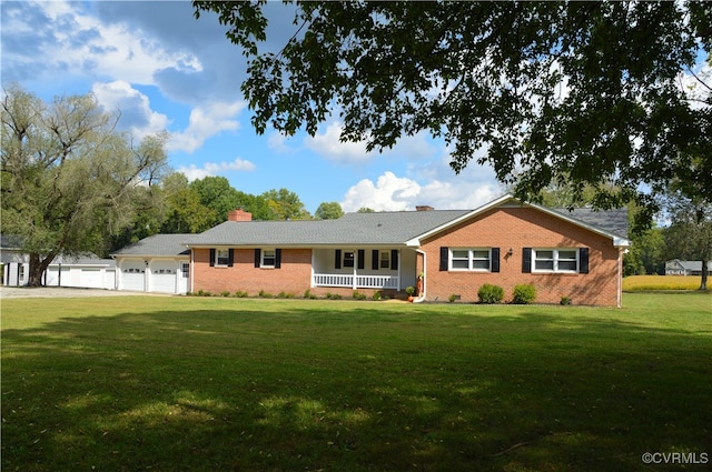 ranch-style home featuring a garage, covered porch, and a front yard