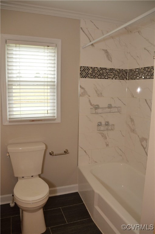 bathroom featuring toilet, ornamental molding, and tiled shower / bath