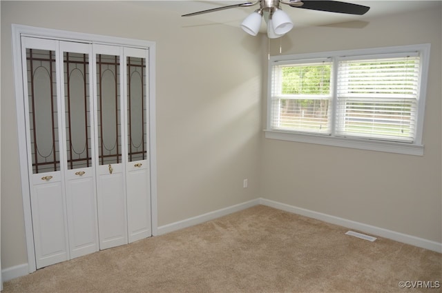 unfurnished bedroom with ceiling fan, a closet, and carpet floors