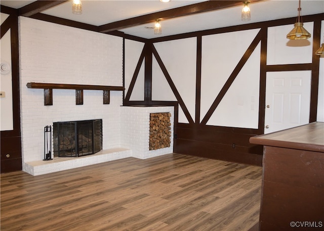 unfurnished living room featuring a brick fireplace, beamed ceiling, and hardwood / wood-style flooring