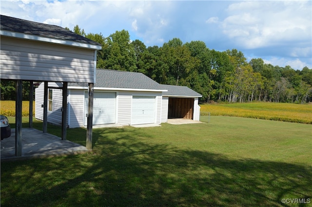 view of yard with a garage, an outdoor structure, and a carport