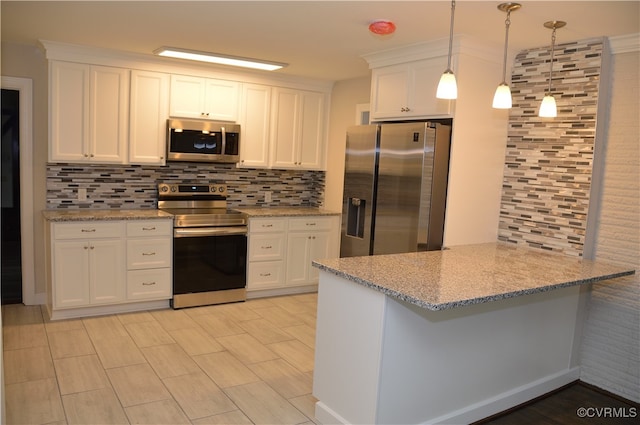 kitchen with hanging light fixtures, stainless steel appliances, light stone counters, decorative backsplash, and white cabinets