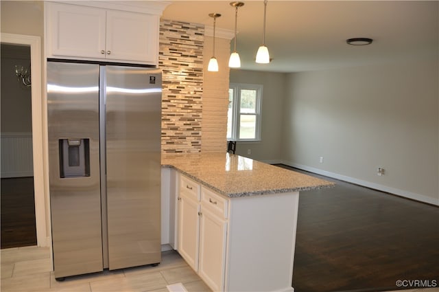 kitchen featuring kitchen peninsula, stainless steel fridge, and white cabinets