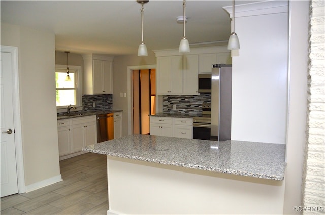 kitchen with white cabinets, kitchen peninsula, and stainless steel appliances